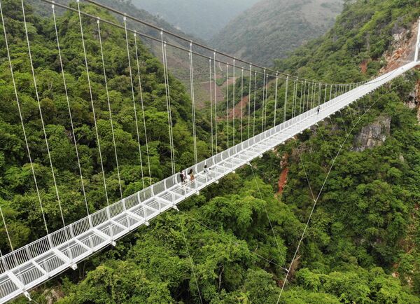 Недавно построенный мост Бах Лонг во вьетнамской провинции Сон Ла со стеклянным дном, подвешенный на высоте около 150 метров над пышным ущельем, покрытым джунглями. - Sputnik Таджикистан