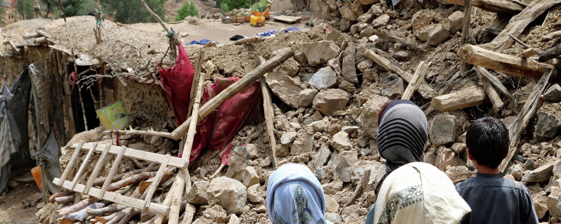 Афганские дети стоят возле дома, который был разрушен в результате землетрясения, Афганистан, 22 июня 2022 г - Sputnik Тоҷикистон, 1920, 09.10.2023