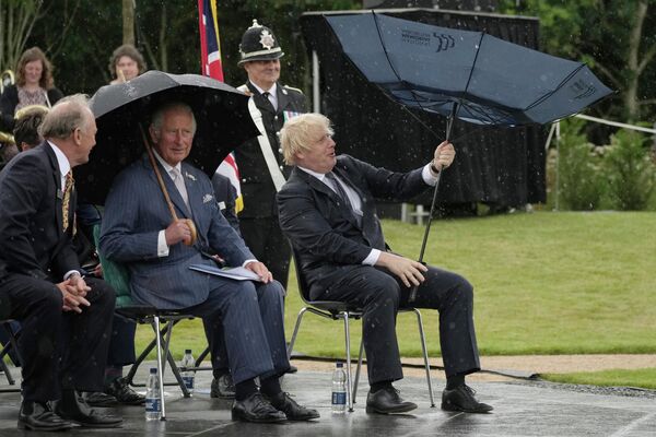 Британский принц Чарльз и премьер-министр Борис Джонсон укрываются от дождя во время открытия Мемориала полиции Великобритании в Национальном мемориальном дендрарии в Алревасе, Англия, 28 июля 2021 года. - Sputnik Таджикистан