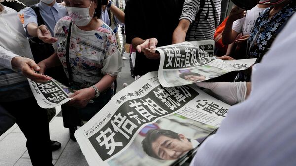Сотрудник распространяет дополнительные выпуски газеты Yomiuri Shimbun с сообщением покушении на премьер-министра Японии Синдзо Абэ 8 июля 2022 года, Токио - Sputnik Тоҷикистон