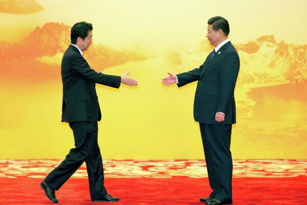 Премьер-министр Японии Синдзо Абэ и председатель КНР Си Цзиньпин во время встречи экономических лидеров Азиатско-Тихоокеанского экономического сотрудничества (АТЭС), Пекин, 11 ноября 2014 г. - Sputnik Таджикистан