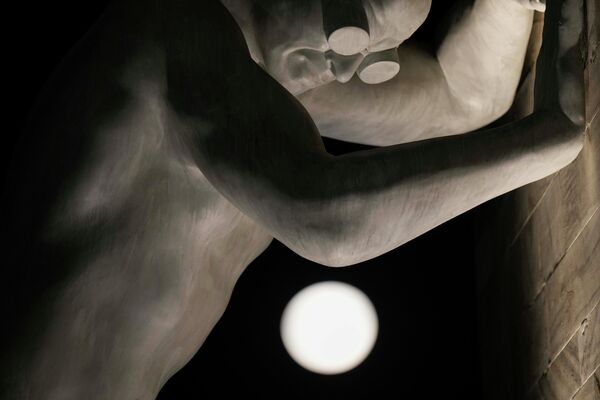 Суперлуна восходит над скульптурой &quot;Мистер Арбитриум&quot; итальянского художника Эмануэле Джаннелли, в Милане, Италия, 13 июля 2022 года. - Sputnik Таджикистан