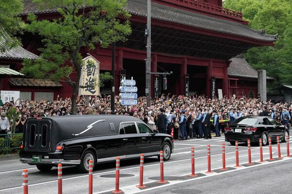 Автомобиль с телом бывшего премьер-министра Японии Синдзо Абэ выезжает из храма Дзодзёдзи после его похорон в Токио. - Sputnik Таджикистан