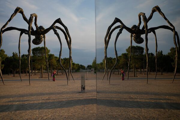 Женщина стоит под 10-метровой монументальной скульптурой &quot;Маман&quot; работы Луизы Буржуа в Культурном центре Фонда Ставроса Ниархоса в Афинах. - Sputnik Таджикистан