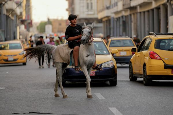 Иракский мальчик едет на лошади во время празднования Ид аль-Адха в центре Багдада. - Sputnik Таджикистан