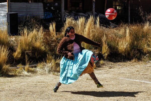 Женщина играет в футбол во время чемпионата в районе аймара в Хули в Пуно, на юге Перу. - Sputnik Таджикистан