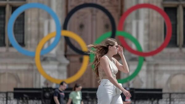 Девушка на фоне олимпийских колец возле мэрии в Париже - Sputnik Таджикистан