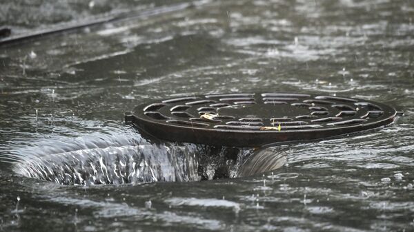Открытый люк сточной канализации во время дождя - Sputnik Тоҷикистон