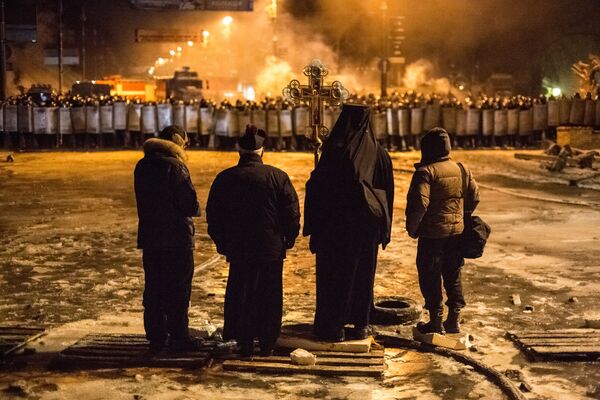 На фото: украинские священнослужители стоят между милицией и оппозицией на нейтральной территории - Sputnik Таджикистан