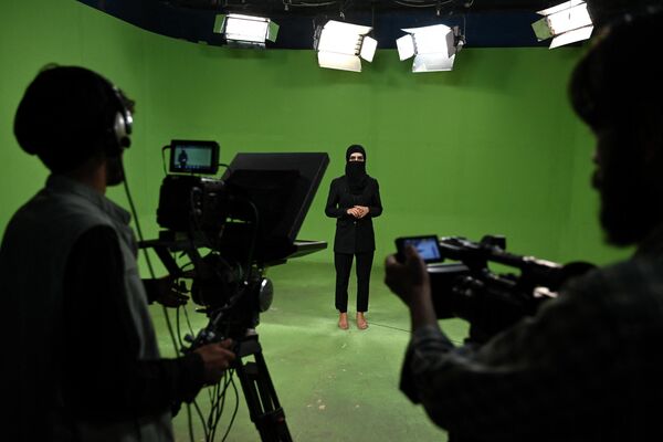 Афганская телеведущая Лима Спесали выступает перед камерами с закрытым паранджой лицом после очередного запрета талибов для женщин. - Sputnik Таджикистан