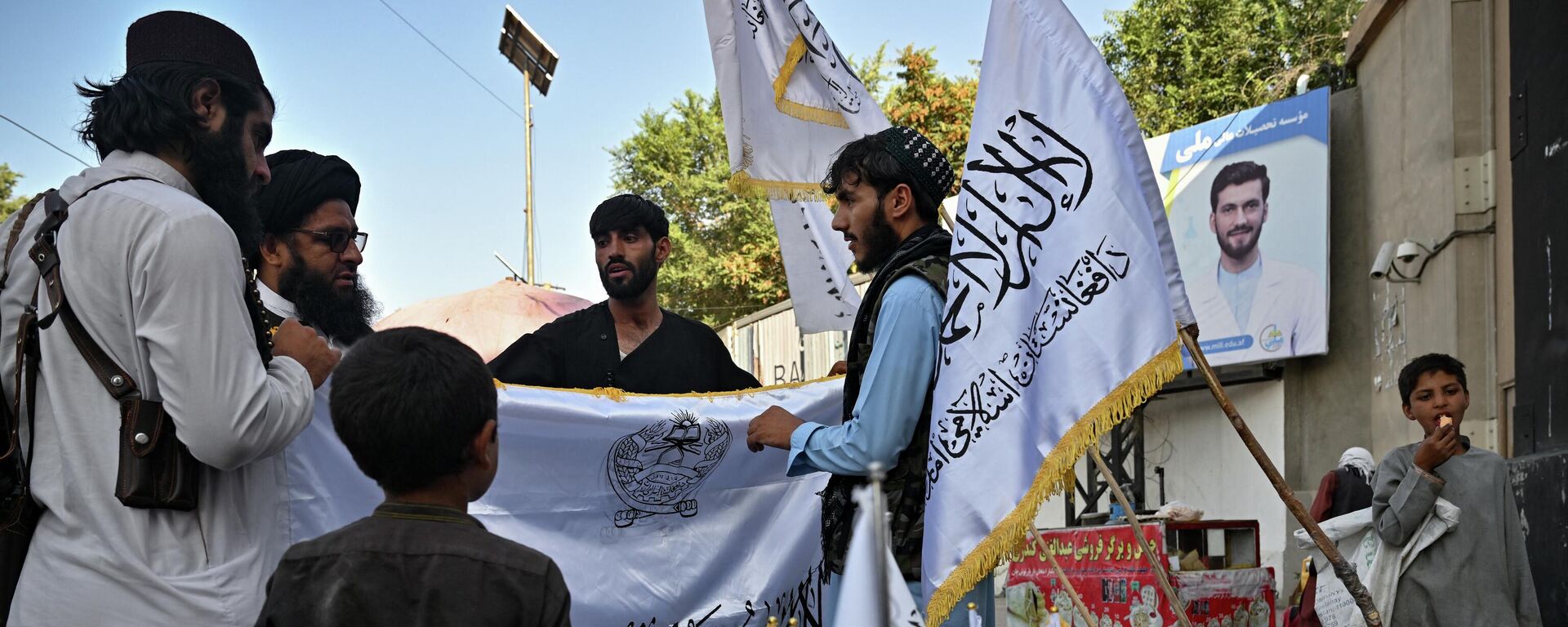 Мужчины покупают талибские  флаги на улице в Кабуле - Sputnik Тоҷикистон, 1920, 04.07.2023