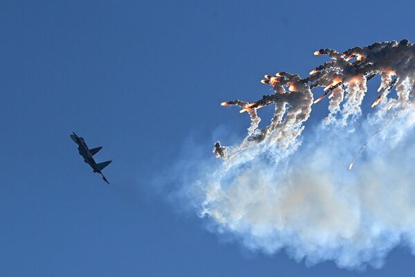 Истребитель МиГ-29 группы высшего пилотажа &quot;Стрижи&quot; во время динамического показа авиатехники выпускает &quot;тепловые ловушки&quot;. - Sputnik Таджикистан