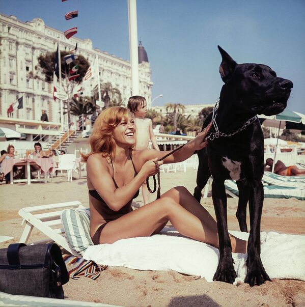 Французская певица Николетта позирует со своей собакой Титусом на пляже Канн во время Каннского кинофестиваля. - Sputnik Таджикистан
