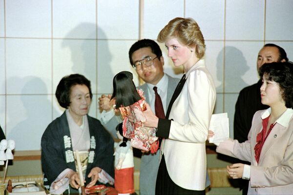 Диана держит традиционную японскую куклу, Токио, 11 мая 1986 года. - Sputnik Таджикистан