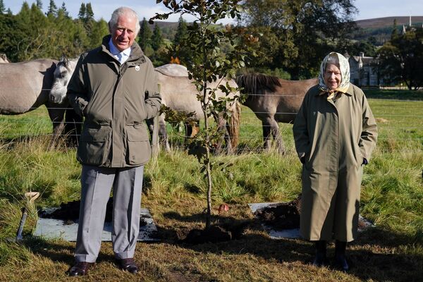 Королева Елизавета II и принц Чарльз рядом с деревом, которое они посадили в поместье Балморал в Шотландии, 1 октября 2021 года. - Sputnik Таджикистан
