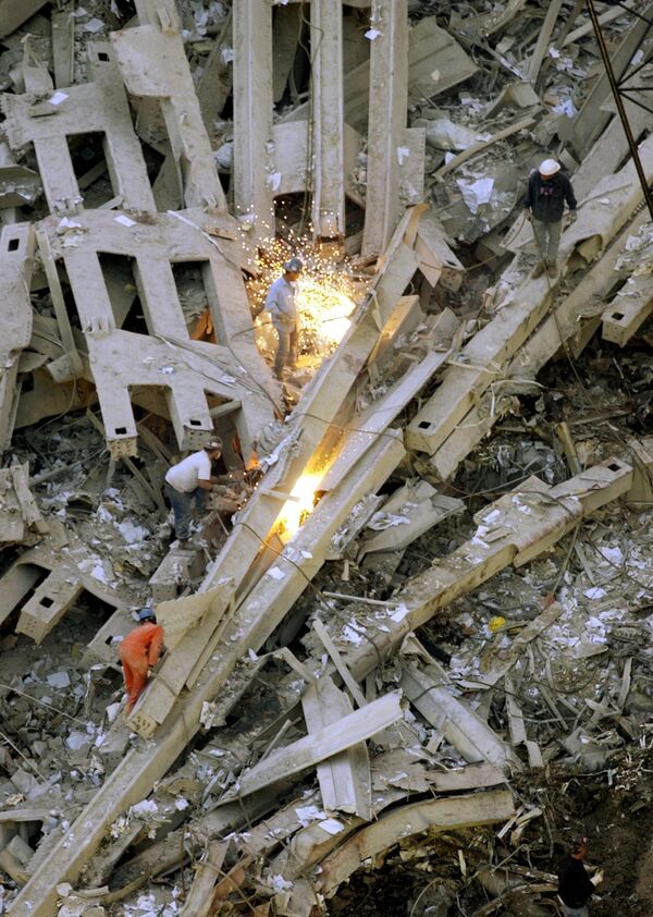 Спасатели, вооружившись факелами, пытаются найти выживших в руинах башен-близнецов Всемирного торгового центра. - Sputnik Таджикистан
