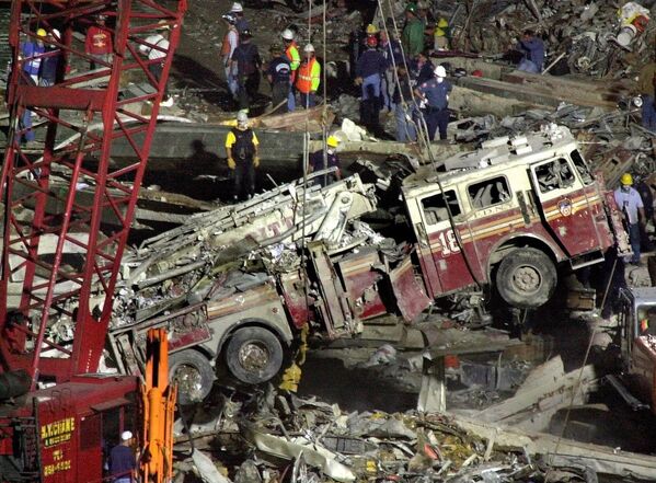 Бригады рабочих поднимают пожарную машину из обломков рухнувшего в Манхэттене торгового центра. - Sputnik Таджикистан