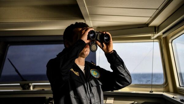 Сотрудник береговой охраны Греции смотрит в бинокль - Sputnik Таджикистан