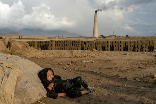 Маленькие дети 4-5 лет спят на земле после работы на кирпичном заводе на окраине Кабула. - Sputnik Таджикистан