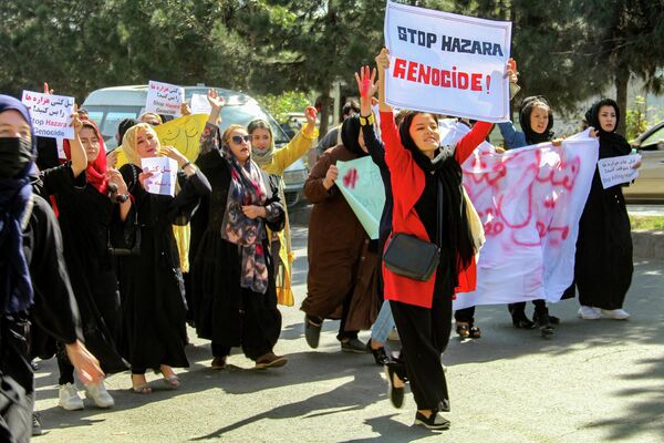 Афганские женщины вывешивают плакаты и скандируют лозунги во время акции протеста. - Sputnik Таджикистан