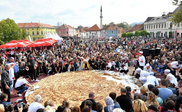 Боснийские повара и их ученики разрезают самый большой в мире бурек на центральной площади в Тузле. - Sputnik Таджикистан