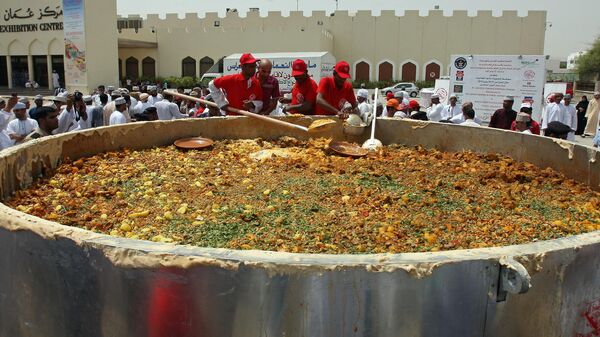 Оманские мужчины перемешивают ингредиенты в большой кастрюле, готовя традиционное блюдо Кабса, пытаясь установить новый мировой рекорд Гиннесса в Маскате 23 июля 2010 года - Sputnik Таджикистан