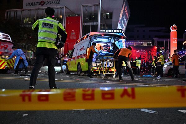 Медбригада увозит человека на носилках скорой помощи после трагедии в Сеуле. - Sputnik Таджикистан