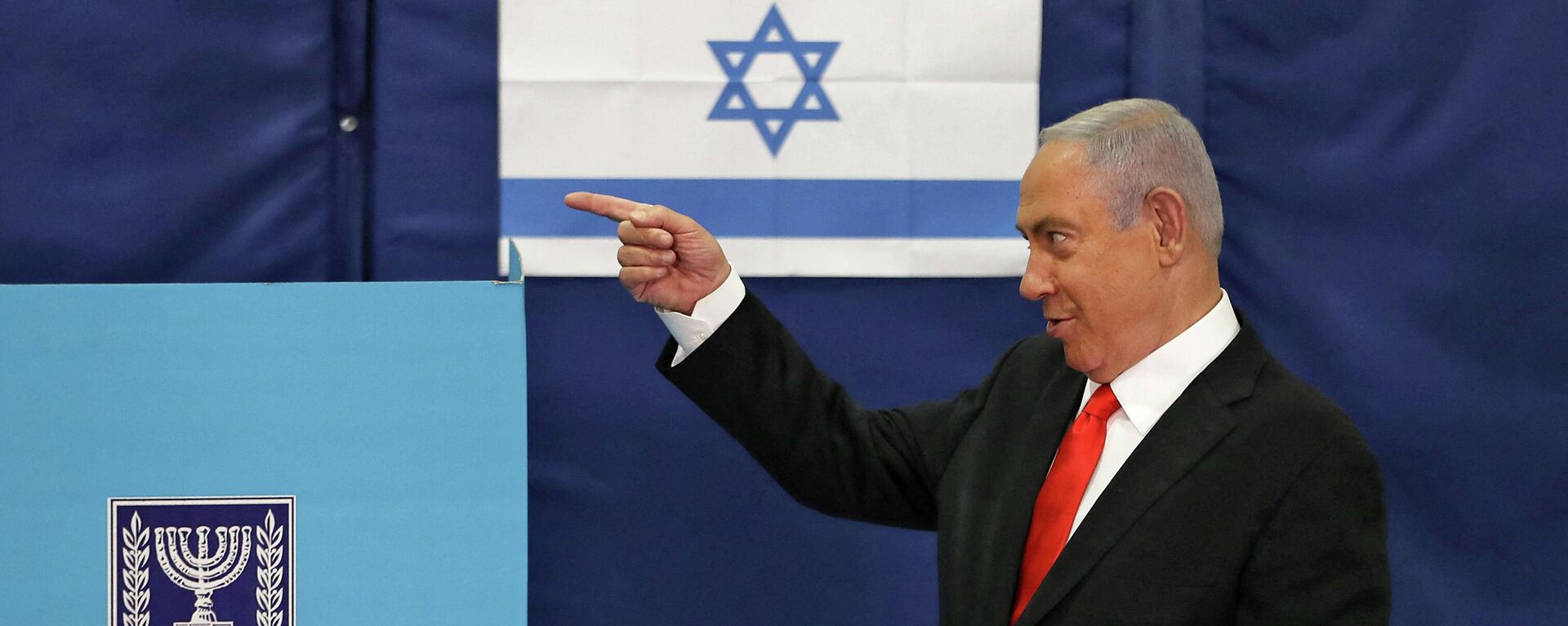Премьер-министр Израиля Биньямин Нетаньяху жестикулирует во время голосования на избирательном участке в Иерусалиме  - Sputnik Тоҷикистон, 1920, 16.10.2023