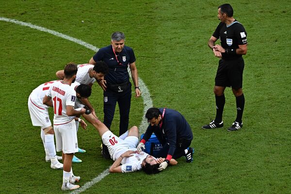 Форвард Ирана #20 Сардар Азмун получает медицинскую помощь во время футбольного матча Кубка мира 2022. - Sputnik Таджикистан
