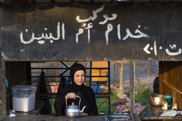 Девушка предлагает чай проходящим иракским паломникам-мусульманам. - Sputnik Таджикистан