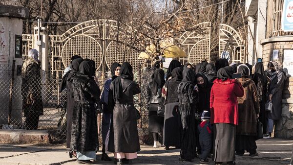 Студентки и сотрудники службы безопасности Талибана  рядом с университетом в Кабуле - Sputnik Тоҷикистон