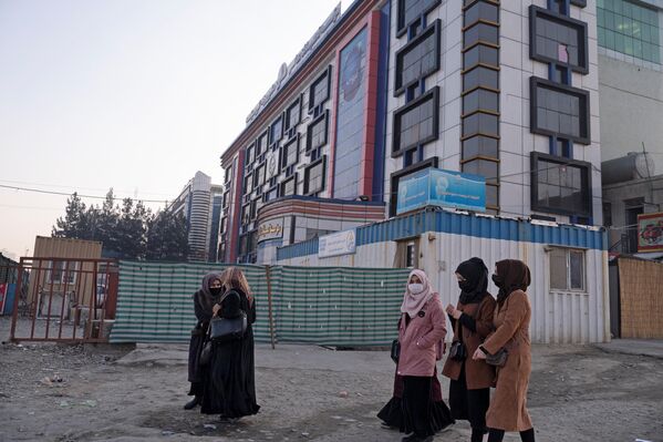 Афганские студентки университета идут мимо частного университета в Кабуле. - Sputnik Таджикистан