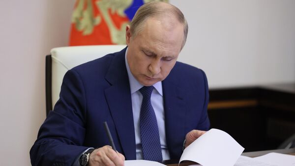 Президент РФ В. Путин подписывает указ. Архивное фото - Sputnik Тоҷикистон