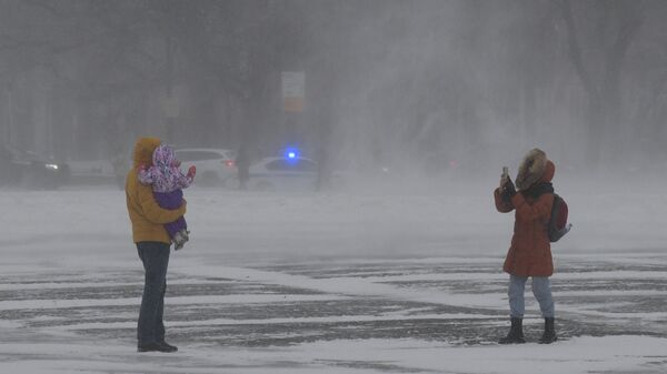 Люди фотографируются на улице во время снегопада - Sputnik Тоҷикистон