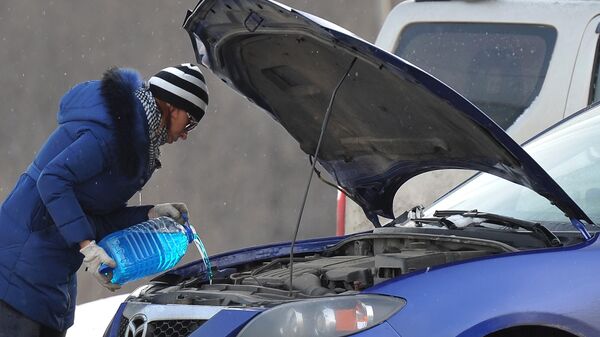 Женщина заливает незамерзающую жидкость в автомобиль, архивное фото - Sputnik Таджикистан