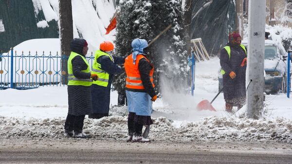 Сотрудники коммунальной службы убирают снег на улице - Sputnik Тоҷикистон