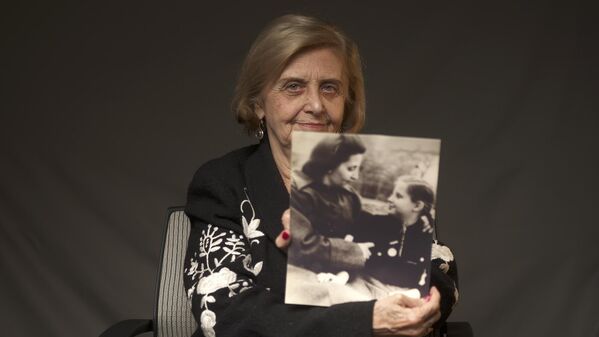 Това Фридман, 82-летняя уроженка Польши, пережившая холокост, показывает свою детскую фотографию с мамой на Всемирном еврейским конгрессе. - Sputnik Таджикистан