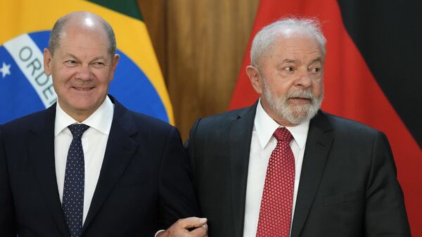Президент Бразилии Лула да Силва (справа) обнимает канцлера Германии Олафа Шольца  - Sputnik Таджикистан
