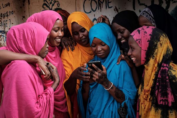 Беженки из Сомали смотрят в смартфон в одном из комплексов для беженцев в Кении. - Sputnik Таджикистан
