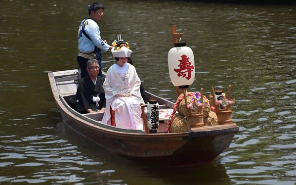А вот японская невеста в белоснежном кимоно подплывает на свадьбу на лодке вместе со своими родителями. - Sputnik Таджикистан