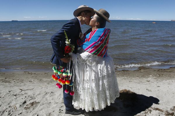 Поцелуй новобрачных на берегу озера Титикака в Перу. - Sputnik Таджикистан