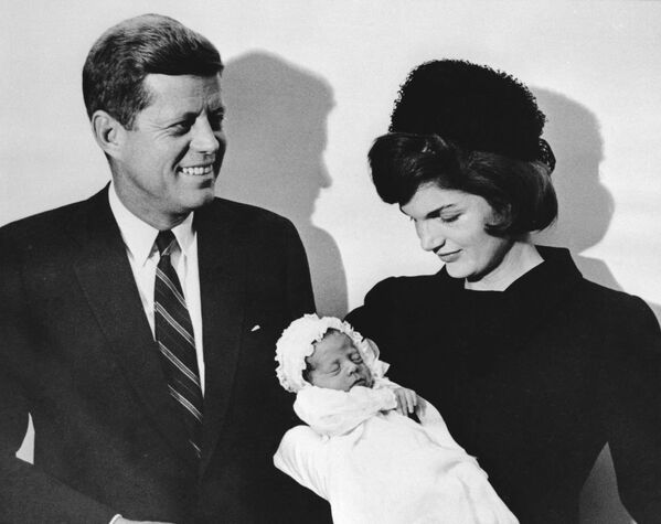 Джон Кеннеди и его жена Жаклин держат сына Джона во время церемонии крещения в часовне в Вашингтоне. - Sputnik Таджикистан
