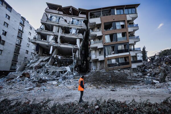 Спасатель в турецком городе Антакья после землетрясения. - Sputnik Таджикистан