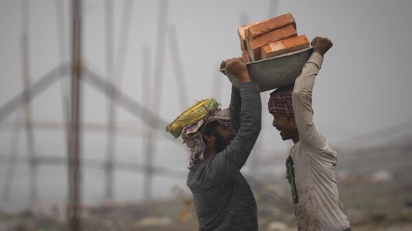 Рабочие несут кирпичи для перевозки по реке Брахмапутра в Гувахати, Индия - Sputnik Тоҷикистон