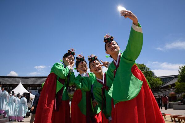 Жительницы Сеула в узнаваемых контрастных костюмах, словно букет алых тюльпанов.   - Sputnik Таджикистан