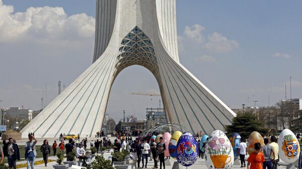 Люди собираются вокруг разноцветных яиц на площади Азади в Тегеране во время празднования Навруза, Иран 20 марта 2023 года - Sputnik Тоҷикистон