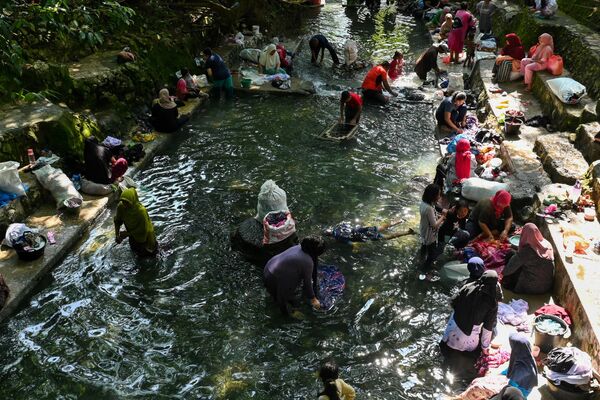 Люди стирают одежду в общественном бассейне с родниковой водой в Джапаке, провинция Ачех, Индонезия. - Sputnik Таджикистан