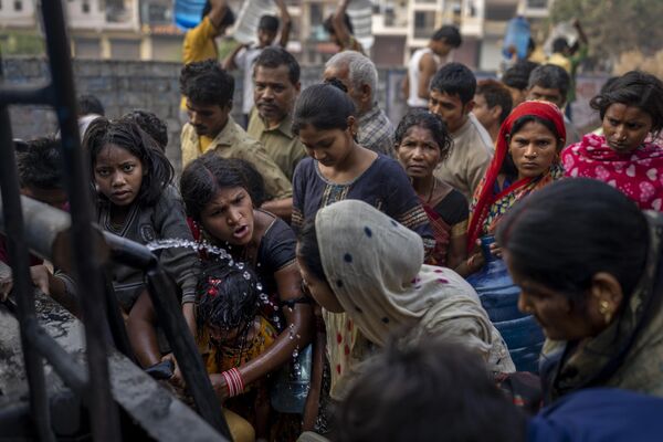 Женщины спорят, набирая питьевую воду из передвижной цистерны Нью-Дели, Индия. - Sputnik Таджикистан
