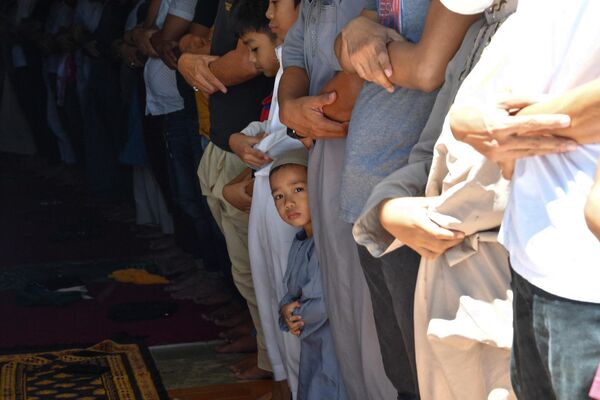 Ребенок молится вместе со своими родственниками в мечети в городе Тагиг в пригороде Манилы. - Sputnik Таджикистан