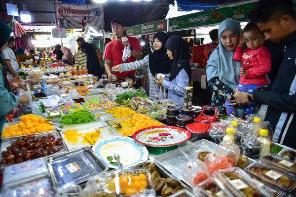 Верующие покупают еду на рынке перед разговением в тайской провинции Наратхиват. - Sputnik Таджикистан